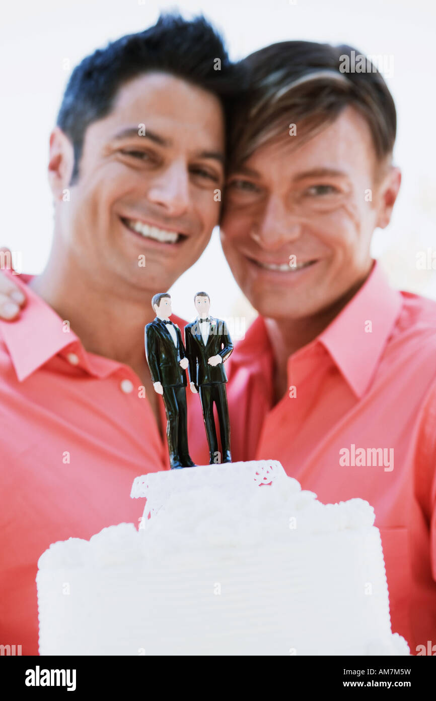 Homosexuell Brautpaar Bräutigam auf ihre Hochzeitstorte anzeigen Stockfoto