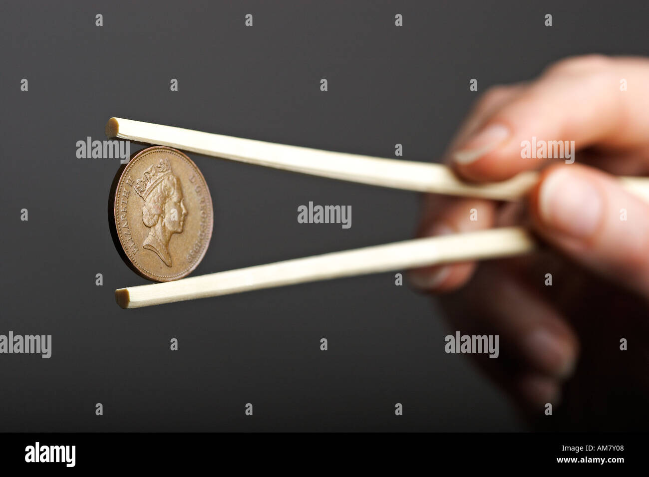 Hand, die britischen zwei Pence-Münze mit Stäbchen, Währung, Geld Stockfoto