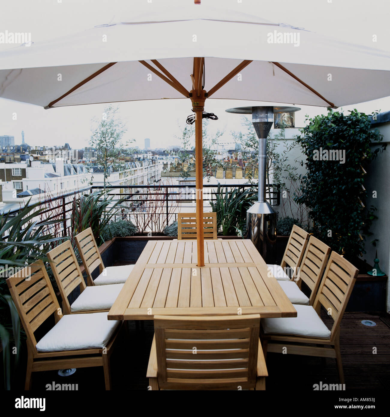 Gartentisch und Stühle mit Sonnenschirm auf der Dachterrasse der Ferienwohnung in London Stockfotografie
