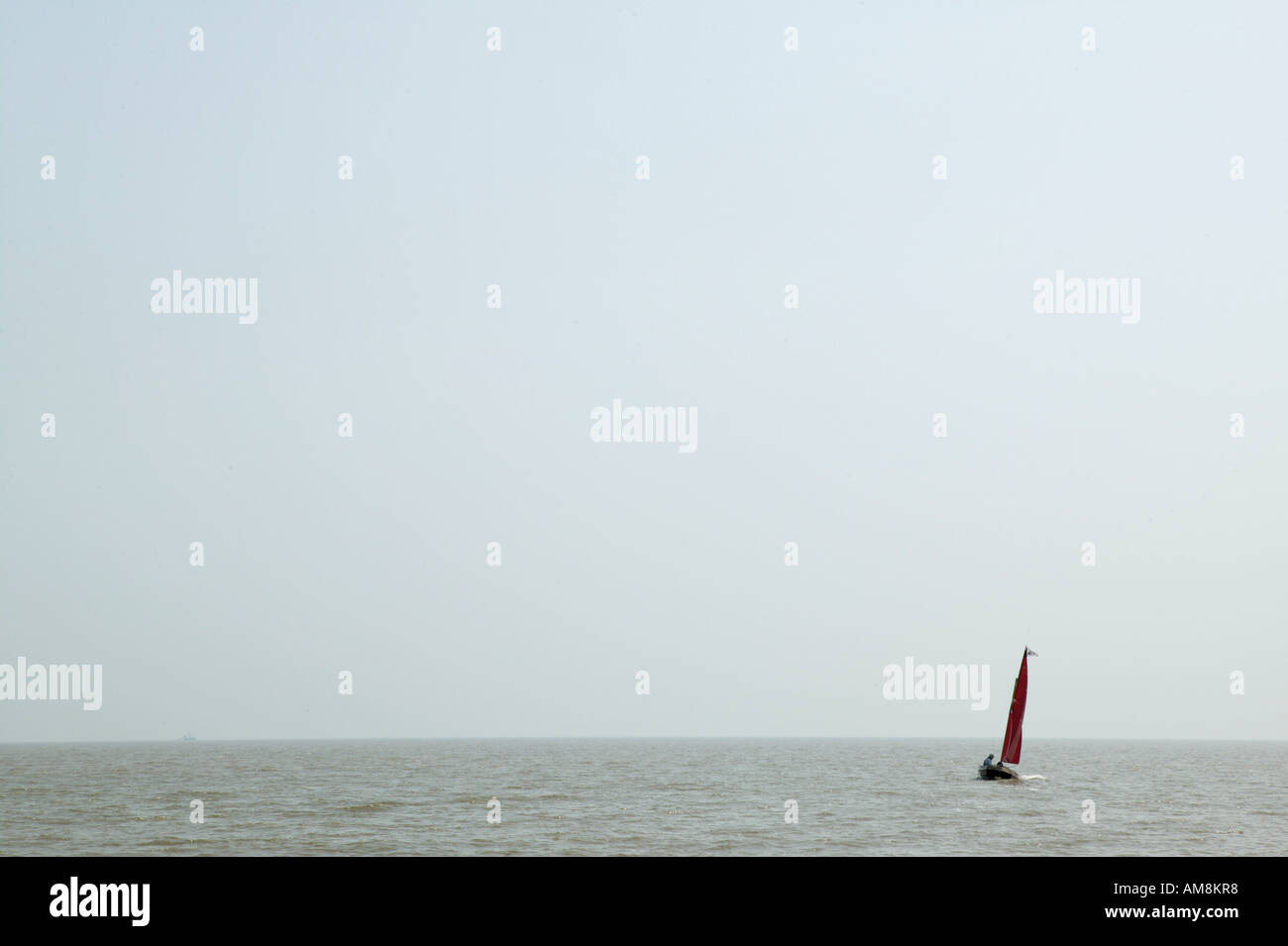 einzelne rote Segelboot in große Wasserfläche. Konzepte von Abenteuer allein einzelne Bootfahren Einzelthemen und Wasser Stockfoto