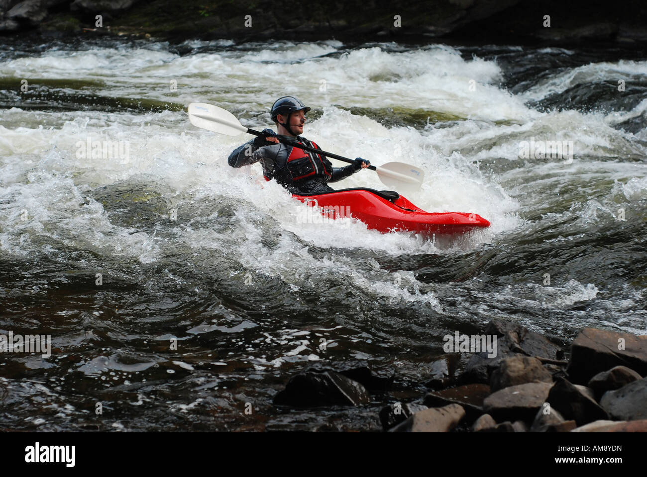 Mann-Kajak im Wildwasser auf einem angeschwollenen Fluss Stockfoto