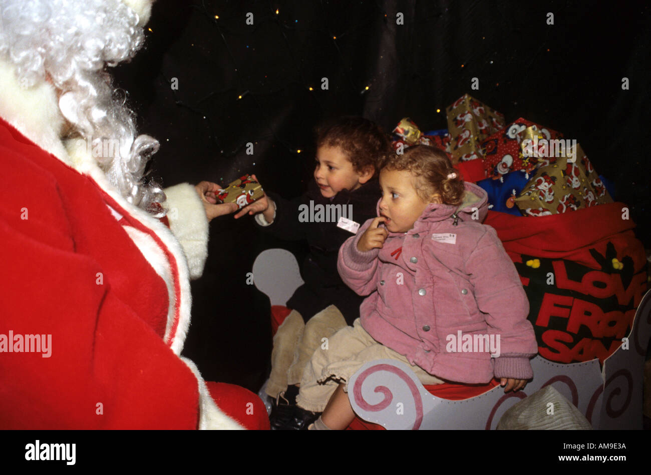 Mädchen, die empfangende vom Weihnachtsmann in seiner Grotte Geschenke Stockfoto