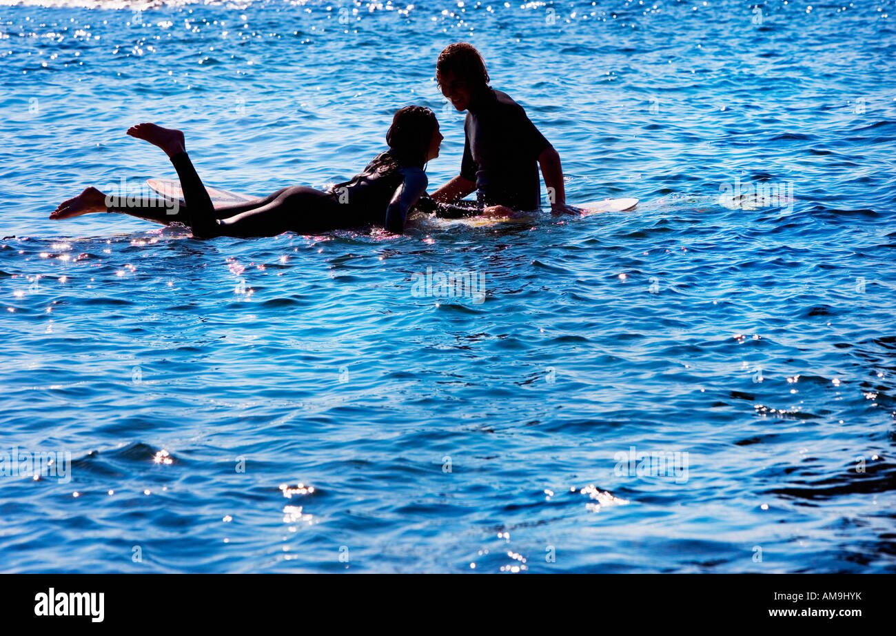 Paar auf Surfbrettern in den Wasser-lächelnd. Stockfoto