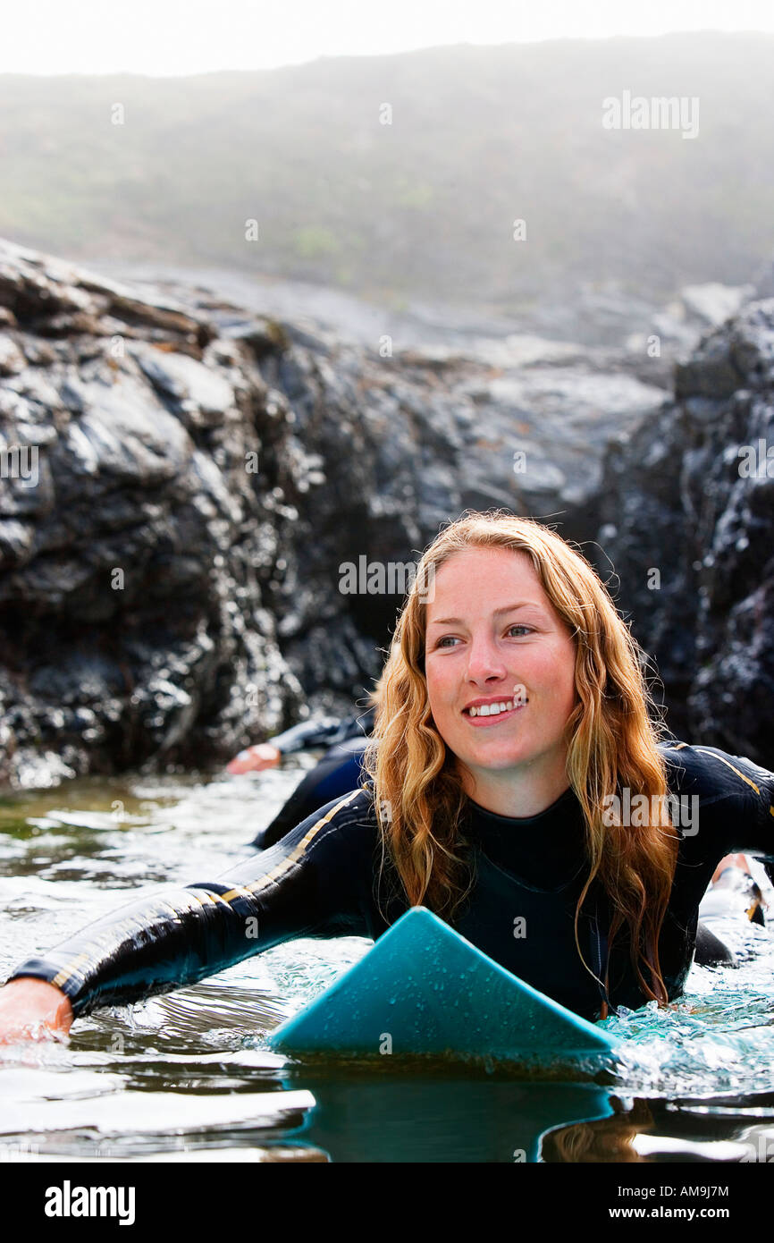 Drei Menschen liegen auf Surfbrettern in den Wasser-lächelnd. Stockfoto