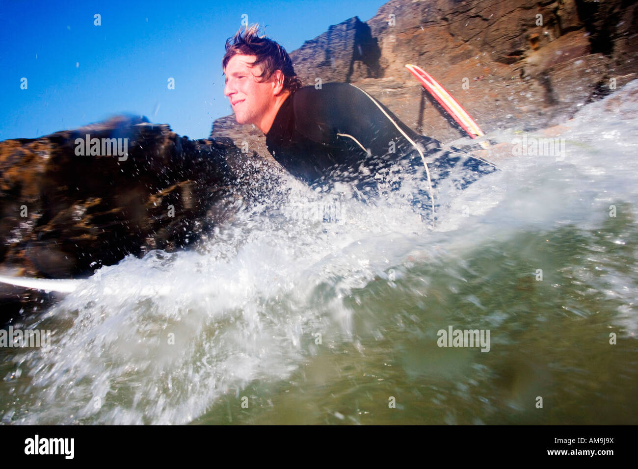 Mann auf Surfbrett im Wasser plantschen. Stockfoto