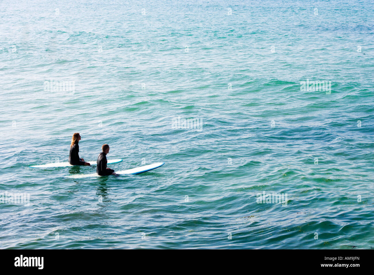 Paar auf Surfbretter im Wasser sitzen. Stockfoto