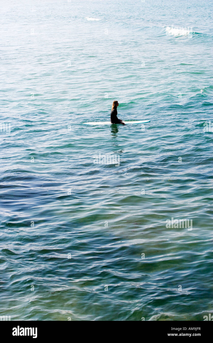 Frau sitzt auf Surfbrett im Wasser. Stockfoto