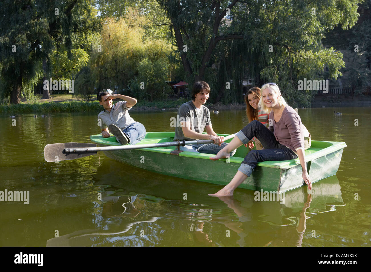Vier Freunde in einem Ruderboot Lächeln auf den Lippen. Stockfoto