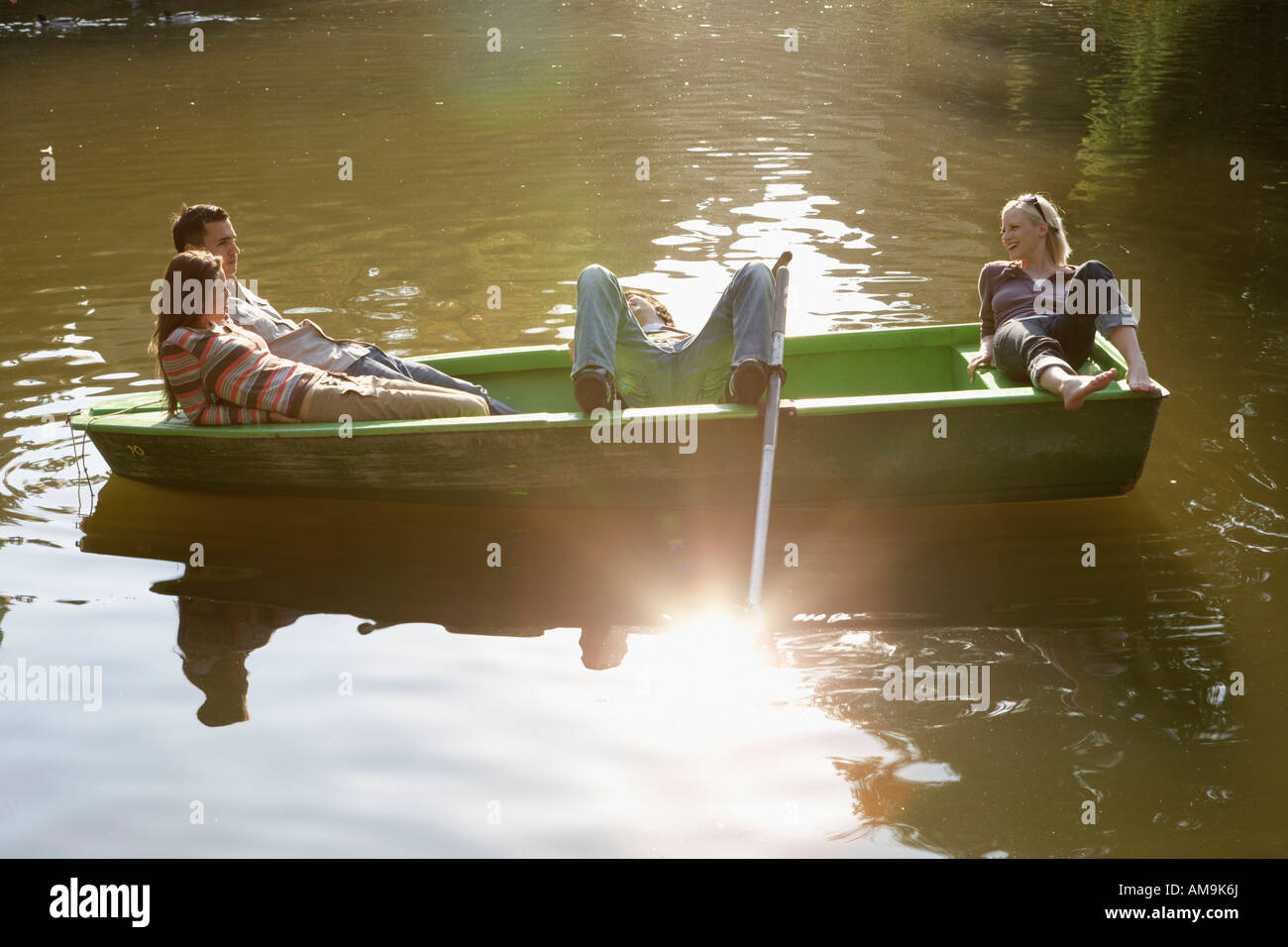 Vier Freunde in einem Ruderboot lächelnd und entspannend. Stockfoto