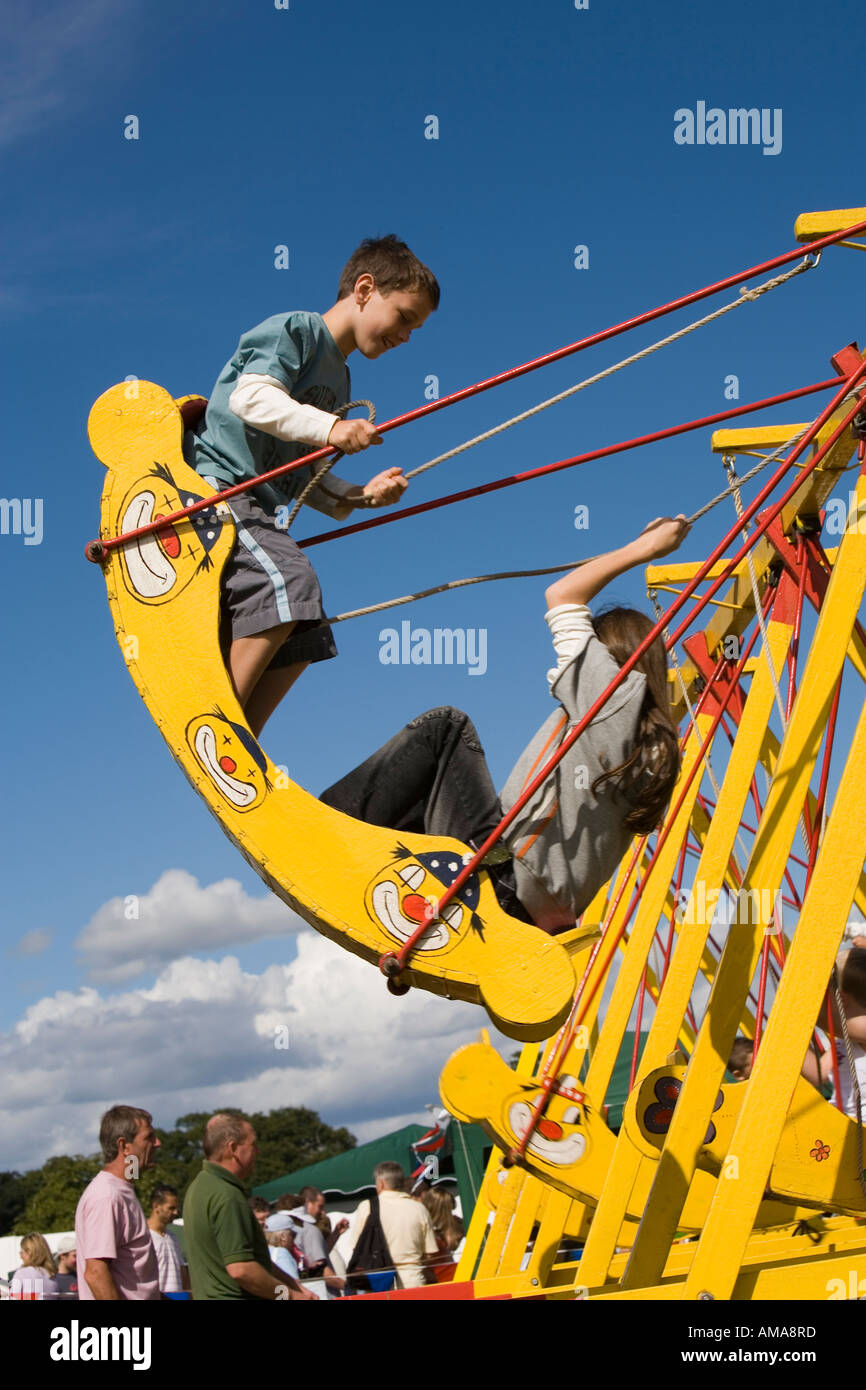 West Sussex Wisborough Green Village Fair auf die grünen Kinder auf der Schaukel Boote Stockfoto