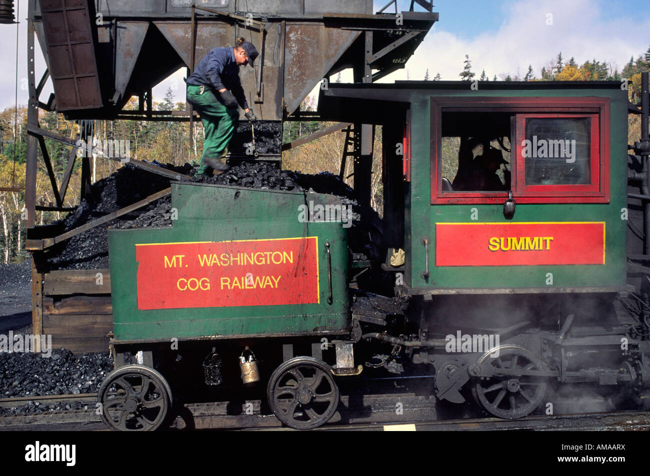 Ein Arbeiter lädt Kohle auf der Mt Washington Cog Railway am Fuße des Mount Washington in New Hampshire Stockfoto