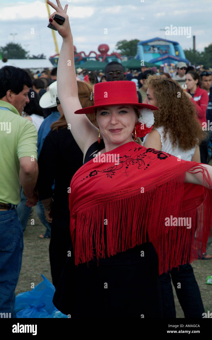 WOMAN IN RED HAT POSIERT FÜR DIE KAMERA IM CARNAVAL DEL PUEBLO BURGESS PARK LONDON 7. JULI 2005 Stockfoto