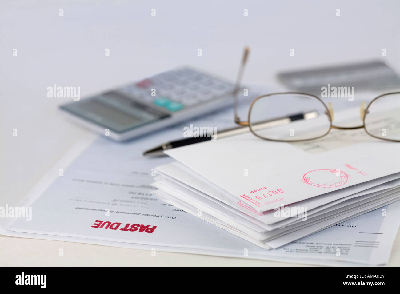 Stapel Umschläge mit Stift, Taschenrechner, Gläser und Kreditkarte Stockfoto