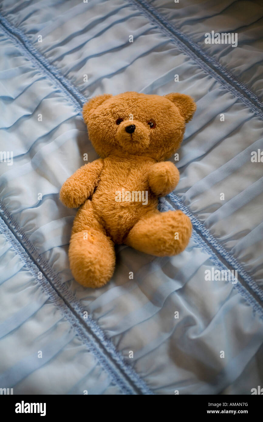 Teddybär auf zerzauste Bettdecke Stockfoto