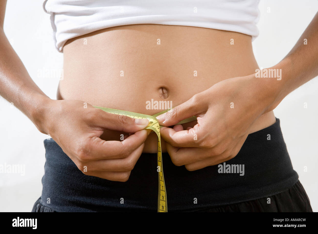 Mittelteil einer Frau, die ihre Taille messen Stockfoto