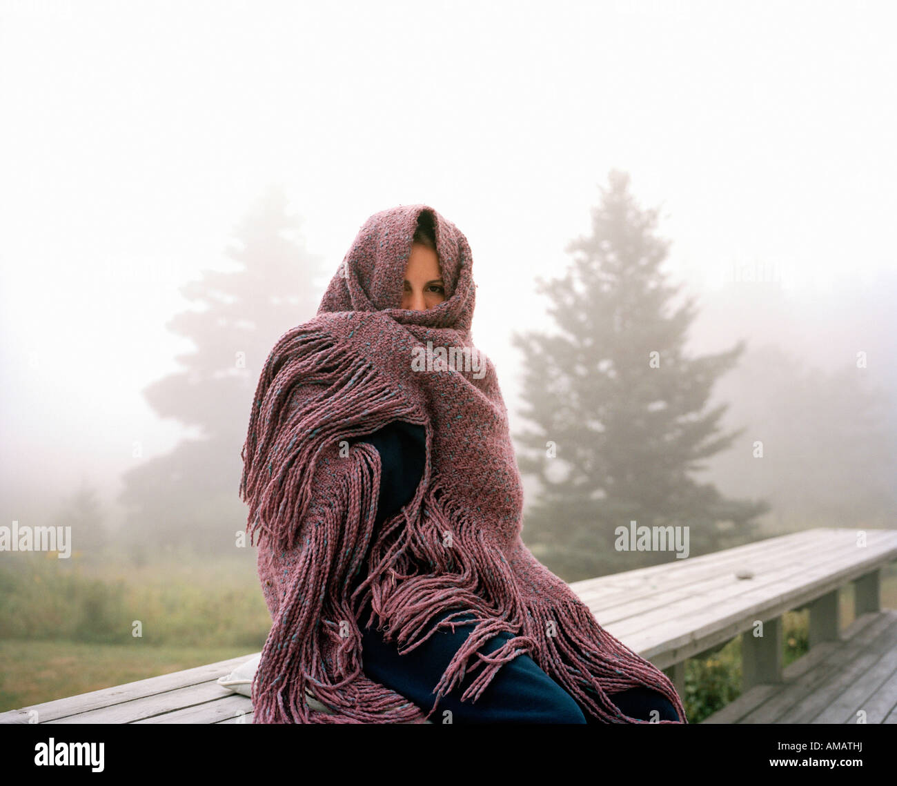 Eine Frau an einem nebligen Morgen in ein Tuch gewickelt Stockfoto