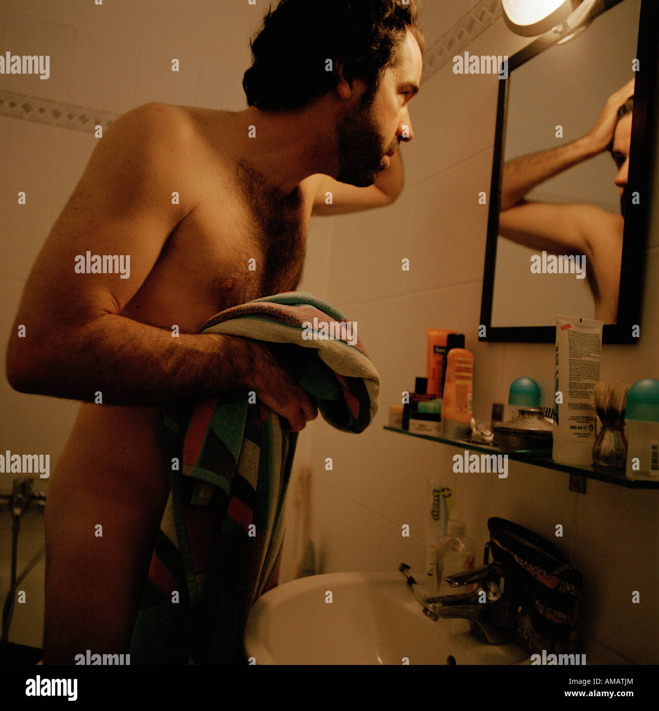 Ein nackter Mann in einem Badezimmerspiegel Stockfoto