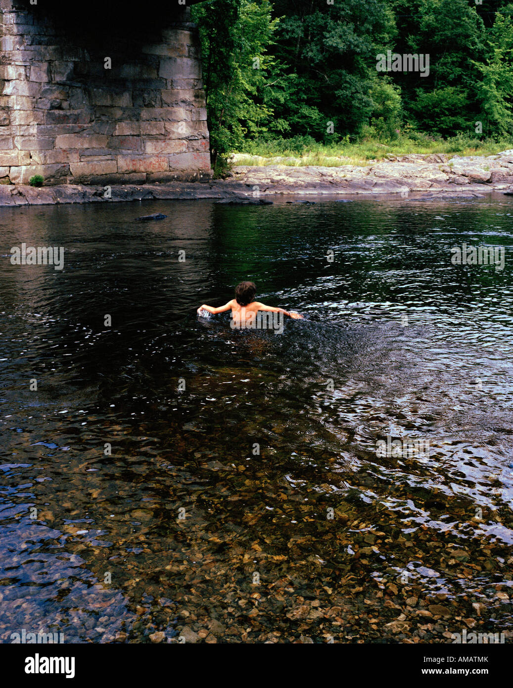 Ein Junge in einem Fluss schwimmen Stockfoto
