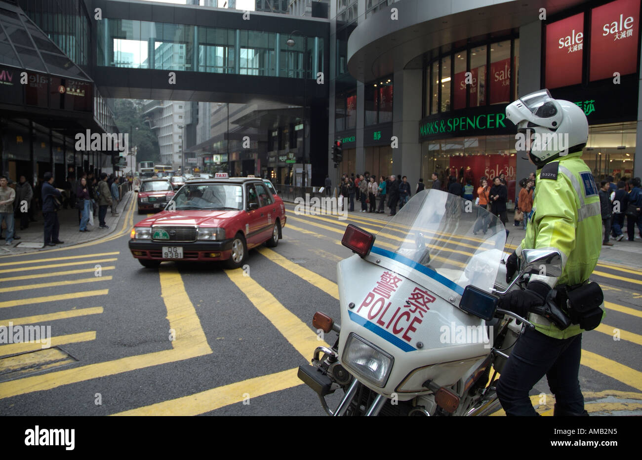 dh des Voeux Rd CENTRAL HONG KONG Motorrad Polizist beobachten Taxi Straße Verkehrskontrolle Polizei Motorrad Stockfoto