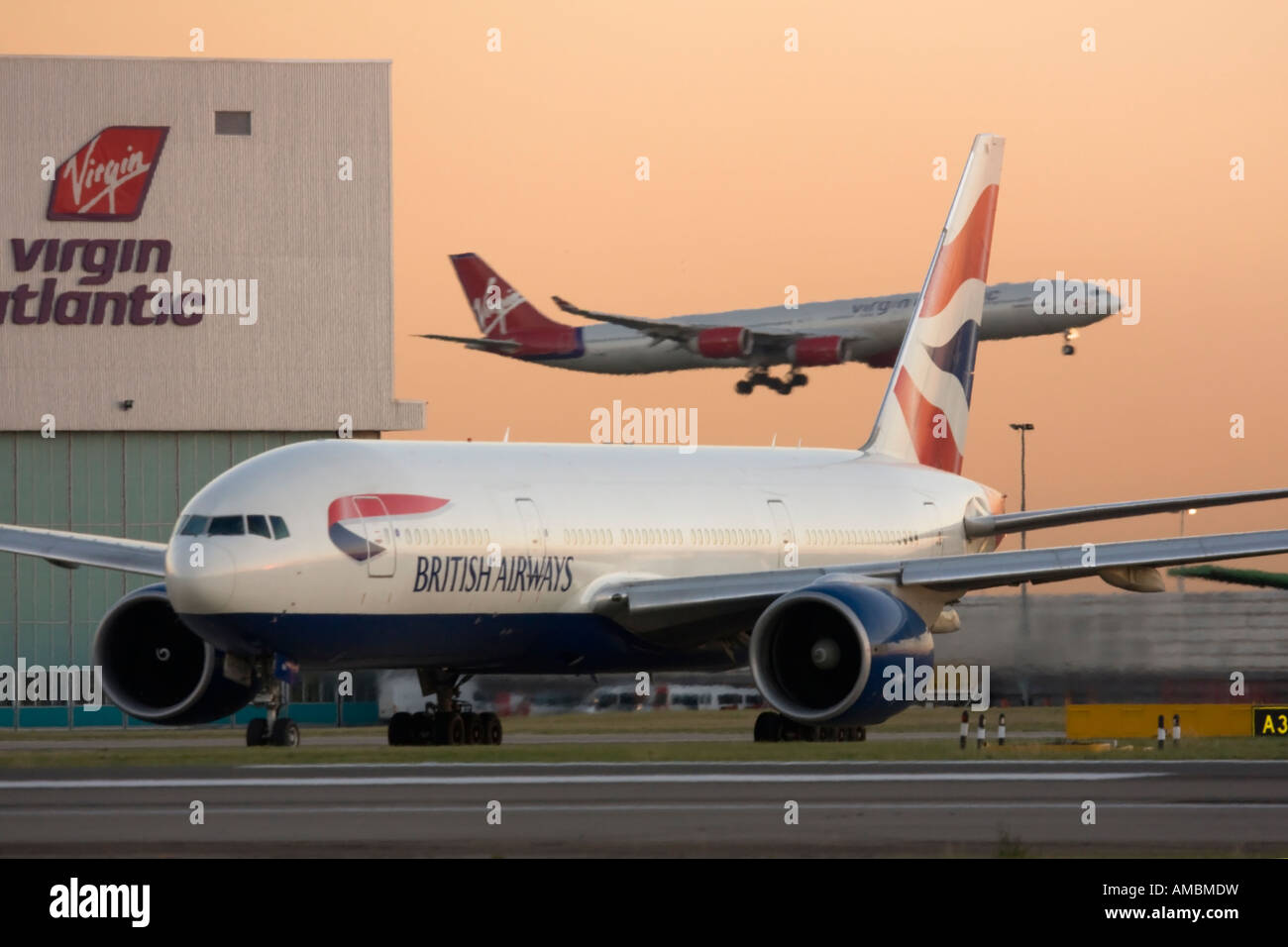 British Airways Boeing 777 des Rollens bei Abreise während Virgin Atlantic Airbus A340 Landung im Hintergrund der Flughafen Heathrow UK Stockfoto