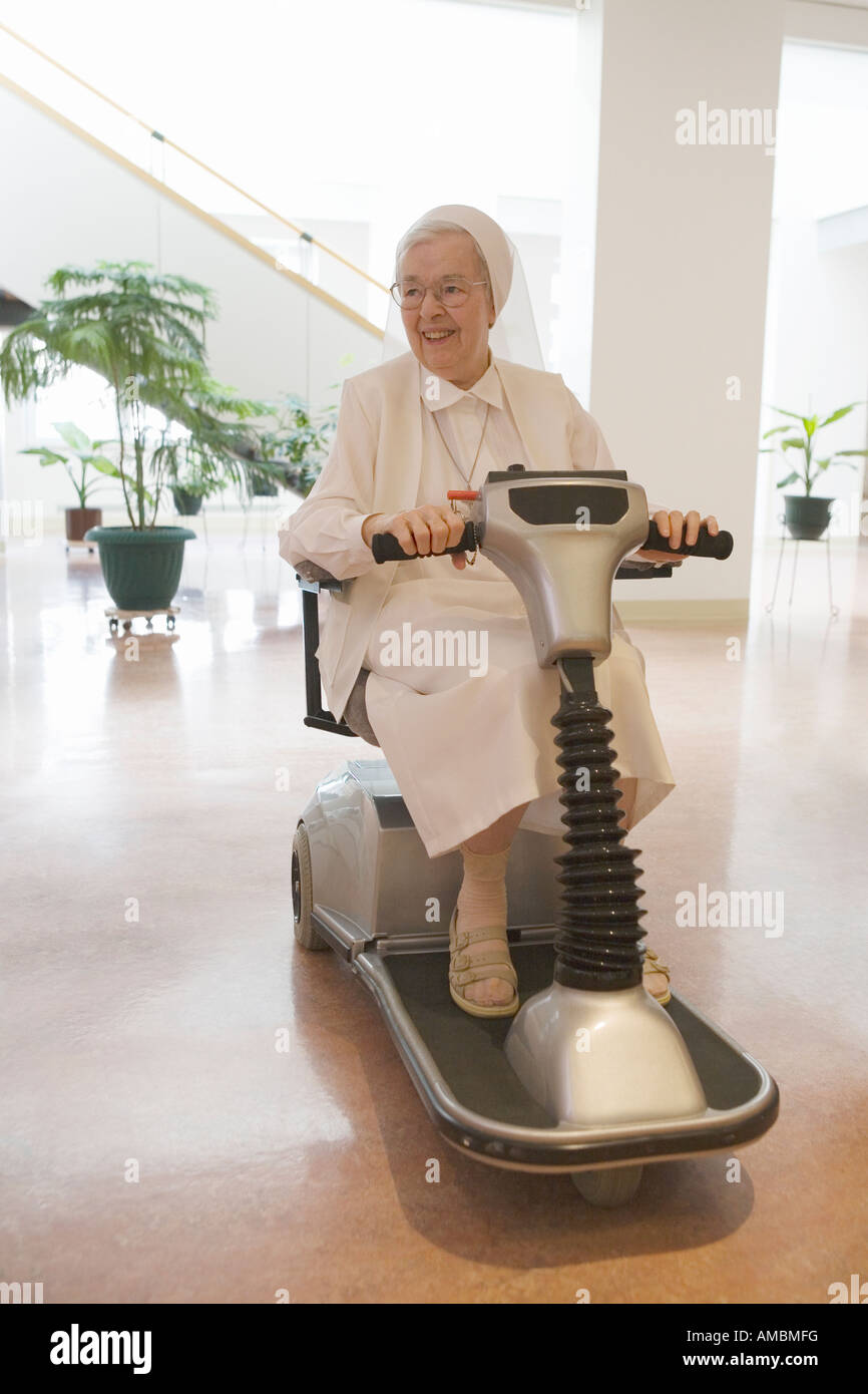 Nonne Reiten einen motorisierten Rollstuhl Stockfoto