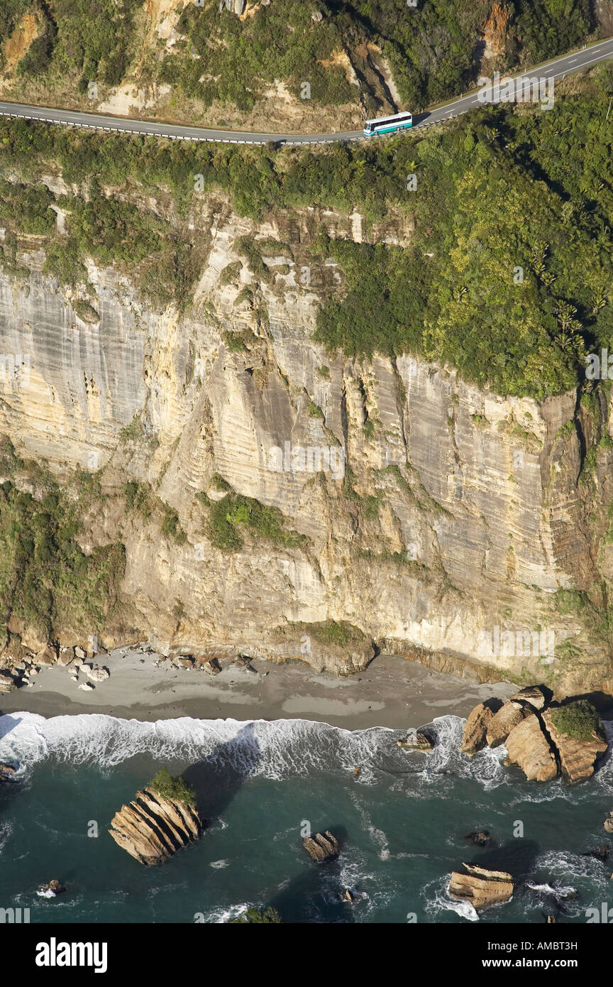Intercity-Bus, Autobahn und Klippen bei Irimahuwheri Bay, senkrecht Punkt Paparoa National Park, West Coast, Südinsel, NZ Stockfoto