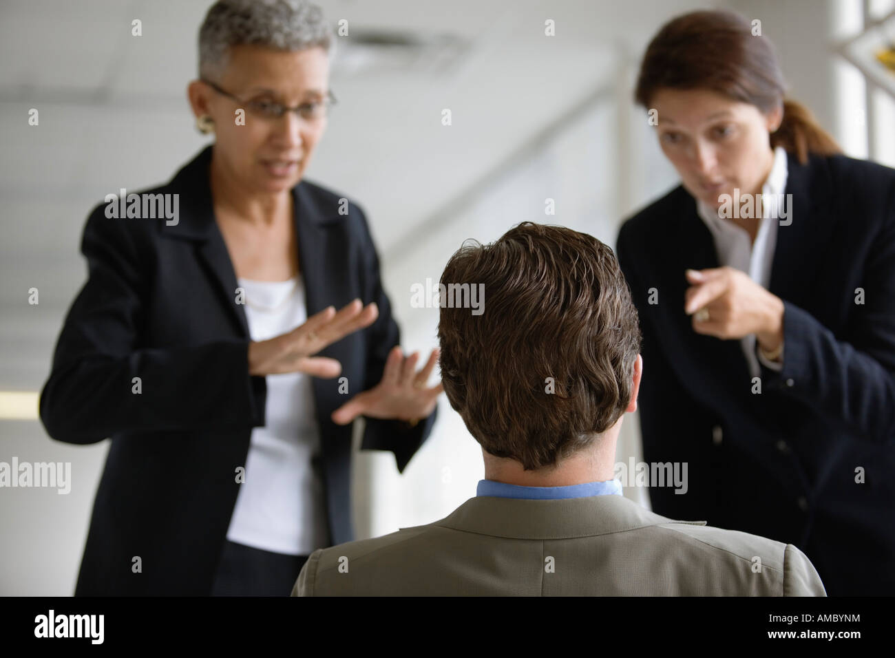 Zwei Geschäftsfrauen verhört einen Mann. Stockfoto