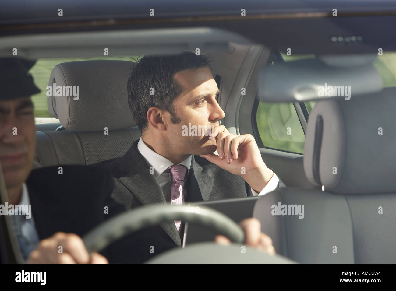 Geschäftsmann in Auto mit Chauffeur Stockfoto
