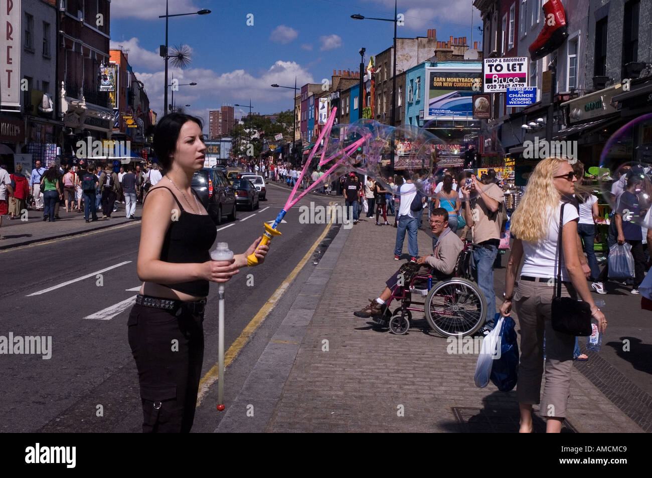Frau große Seifenblasen auf einer Straße, Camden High Street, Camden Town, London, England Stockfoto