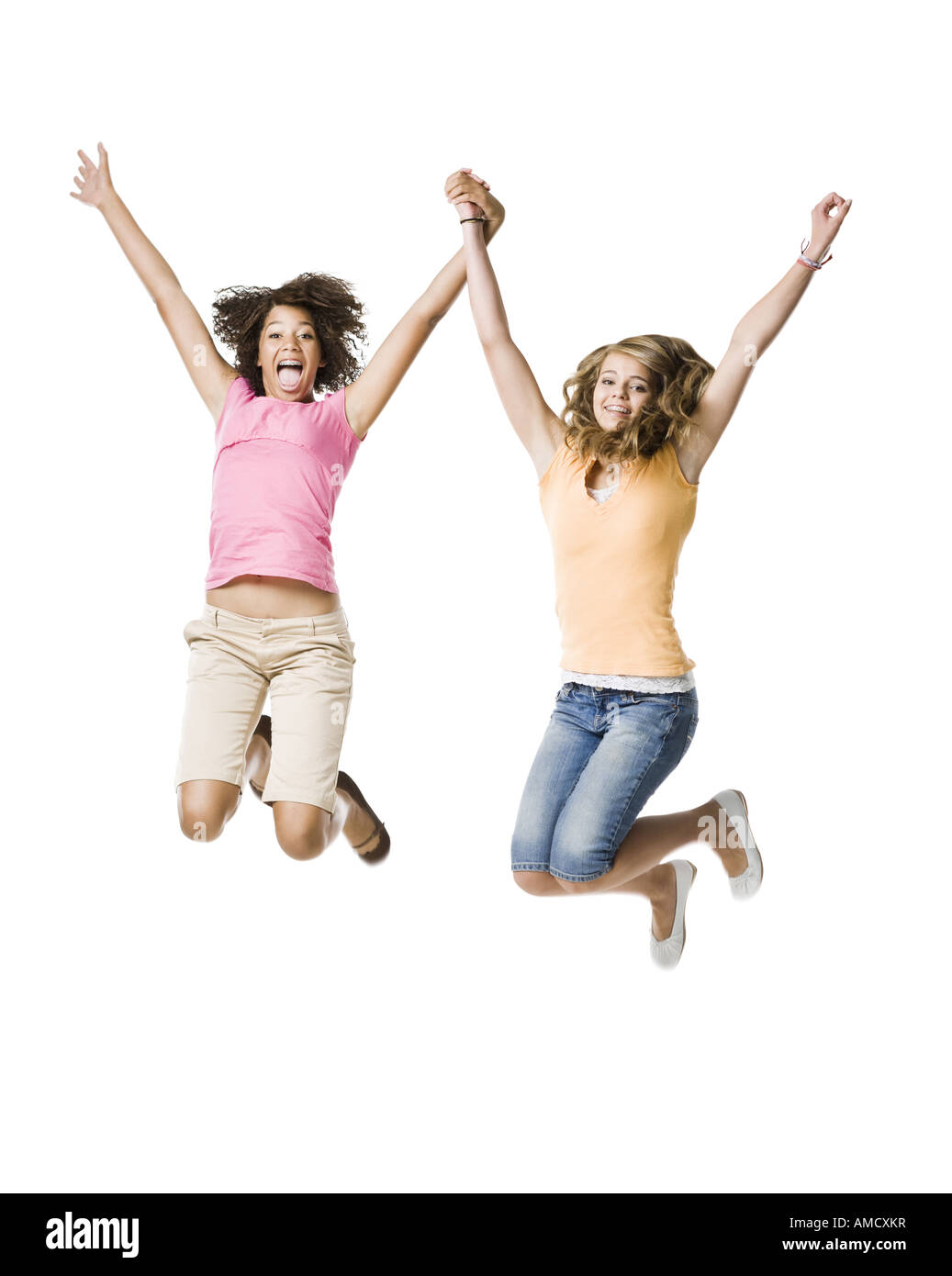 Zwei Mädchen mit Zahnspange Händchenhalten und springen Stockfoto