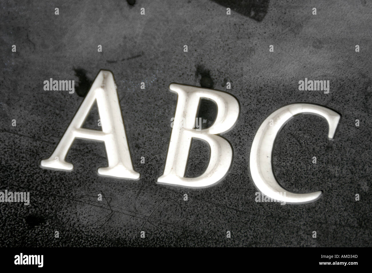 "Abc" eingraviert in einer dunklen Oberfläche. Stockfoto