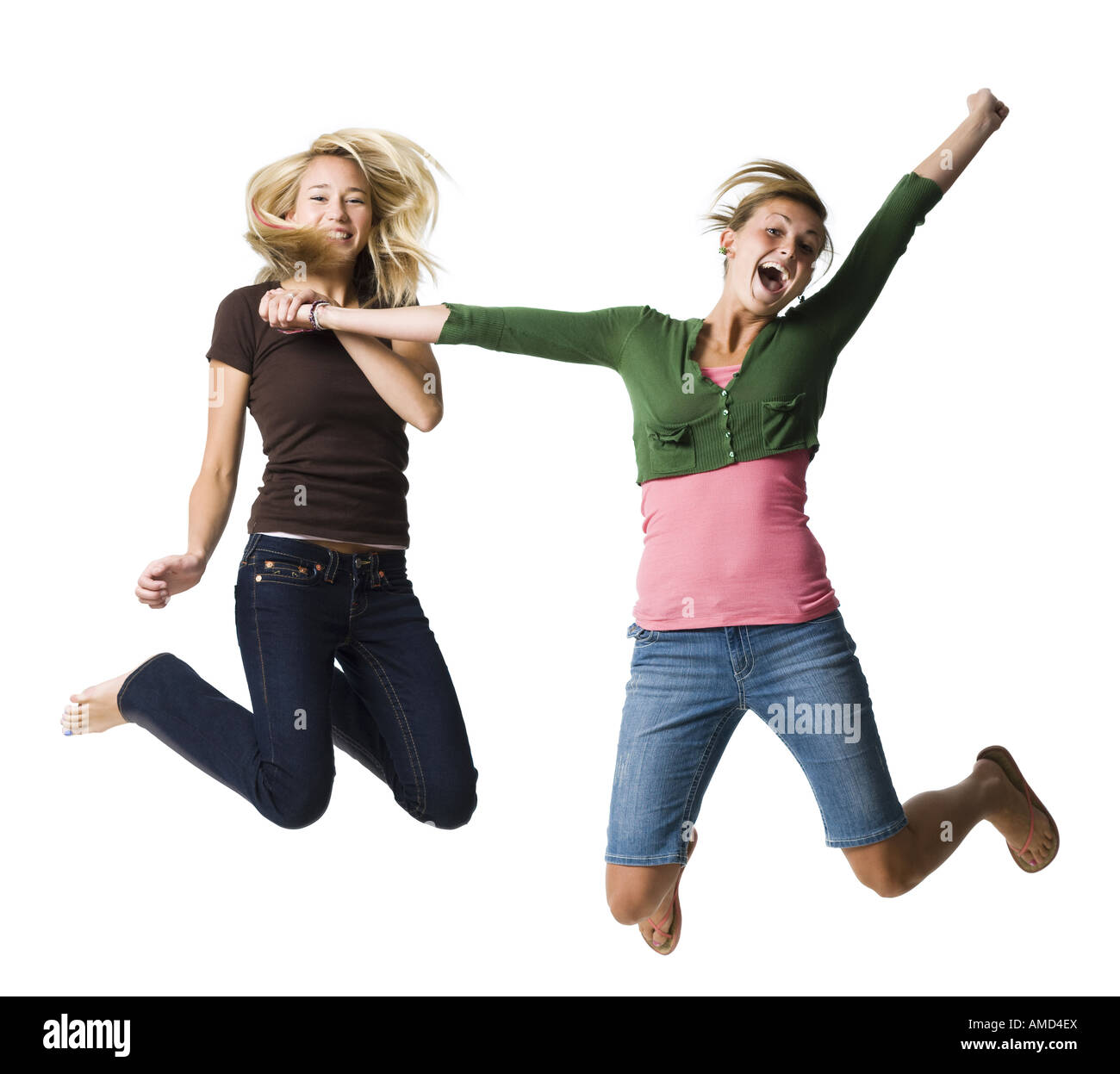 Zwei Mädchen im Teenageralter springen und lächelnd Stockfoto
