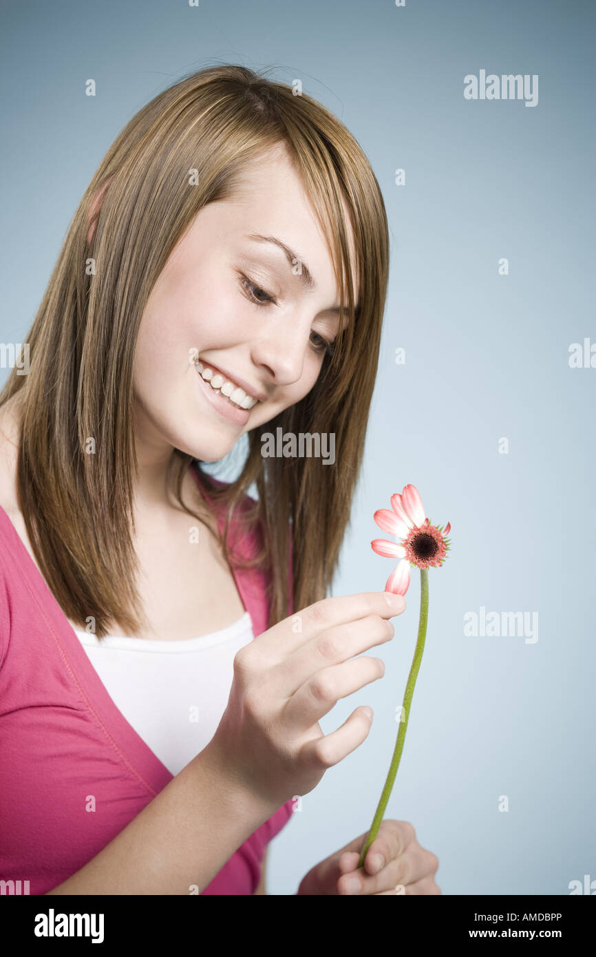 Mädchen, die Blütenblätter aus lächelnde Blume pflücken Stockfoto