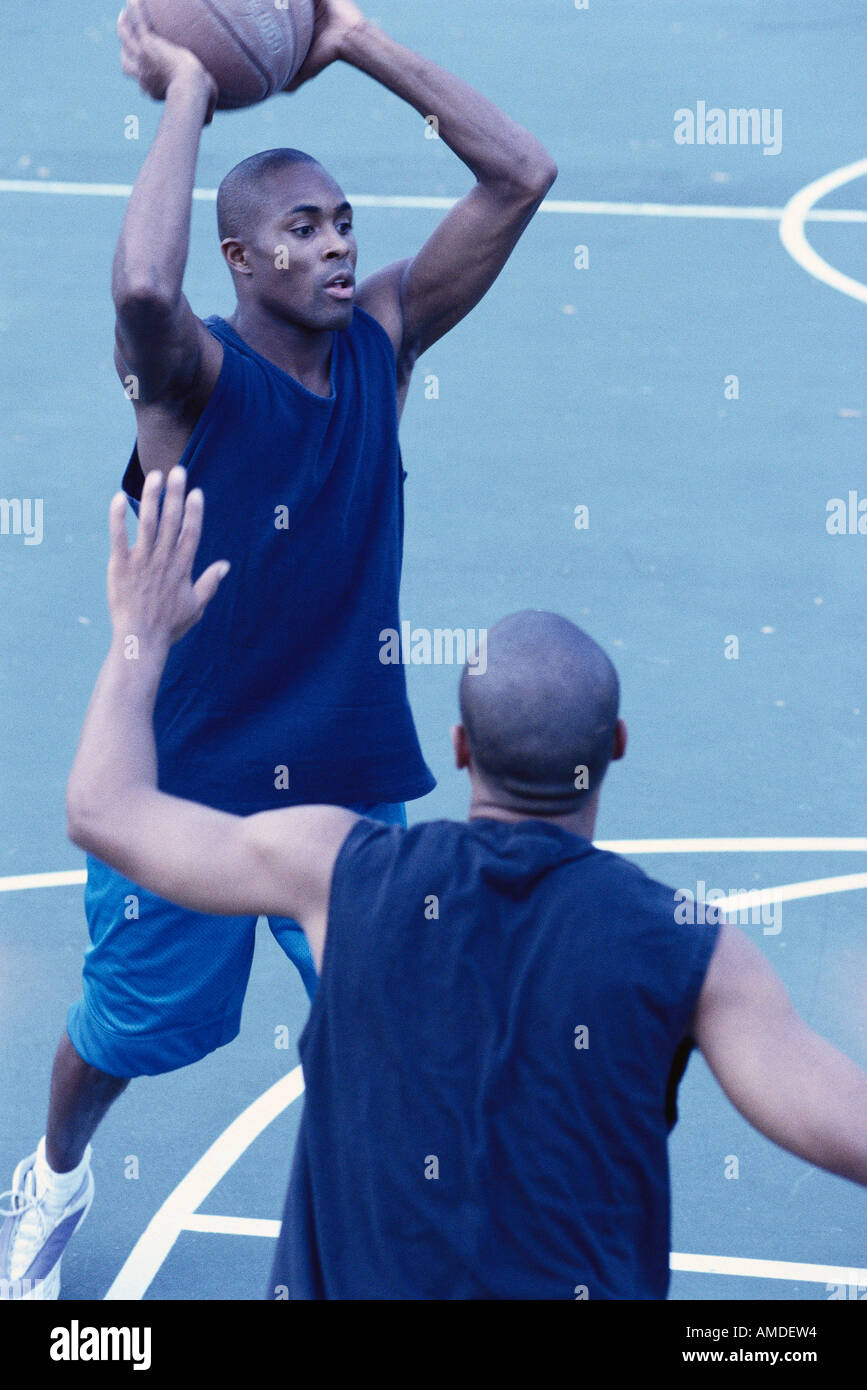 Männer spielen Basketball im freien Stockfoto