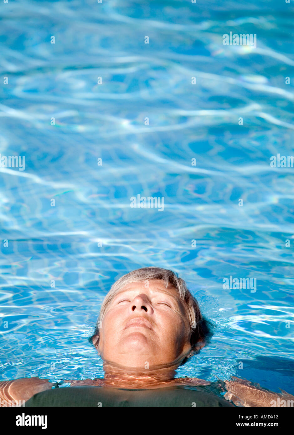 Eine reifere Frau entspannend in einem Schwimmbad Stockfoto