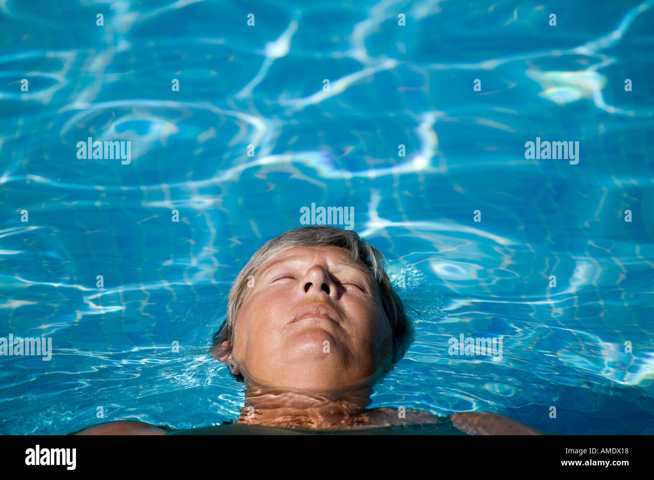 Eine reifere Frau entspannend in einem Schwimmbad Stockfoto