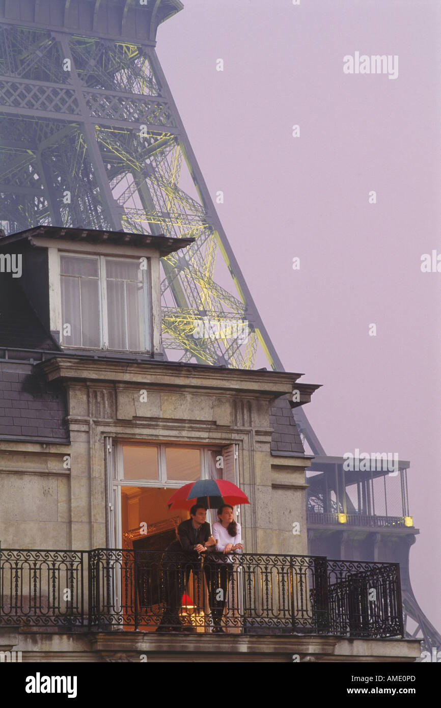 Paar auf Balkon unter Dach und sanften Sommerregen in der Nähe von Eiffelturm in Paris Stockfoto