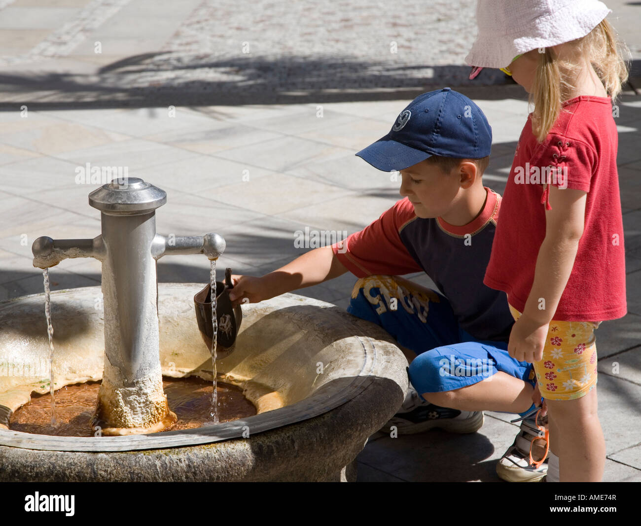 Kinder Trinkbecher mit Mineralwasser in den Pramen Svoboda füllen Frühling Karlovy Vary Tschechien Stockfoto