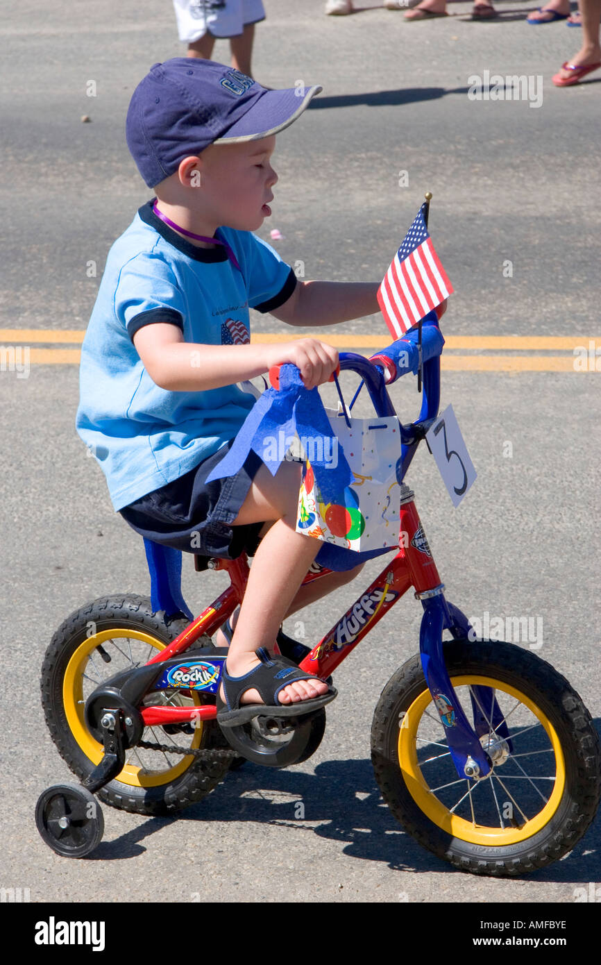Ein kleiner Junge reitet auf seinem Fahrrad in einer Kleinstadt Fourth Of July Parade in Cascade, Idaho. Stockfoto