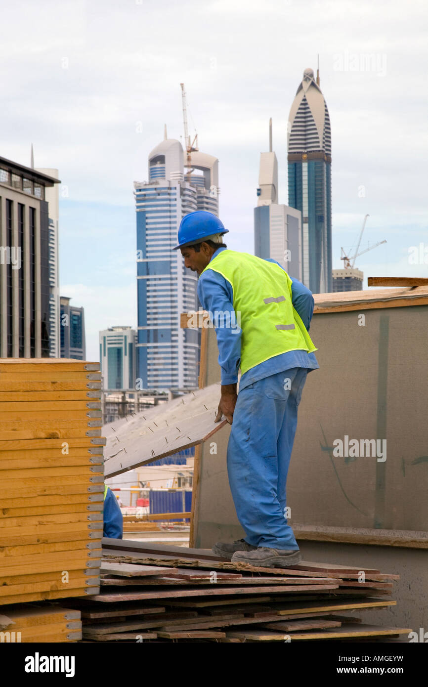 Handwerker vor Ort an der unvollendeten, unvollständige Hochhaus Gebäude; zugewanderten ausländischen Bau Projekt mitarbeiter Aufbau der neuen Dubai. UAE Stockfoto