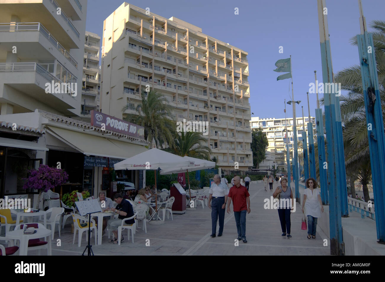 Touristischen Spaziergang entlang der Promenade, gesäumt von high-Rise Wohnungen, Läden, & Restaurants in Marbella, Andalusien Südspanien Stockfoto