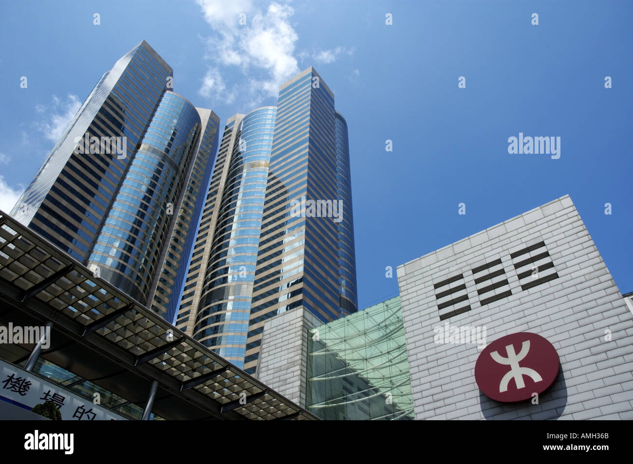 Eingang zur u-Bahn MTR Logo Zeichen mit den Exchange Square Wolkenkratzern im Hintergrund, Hong Kong, China. Stockfoto