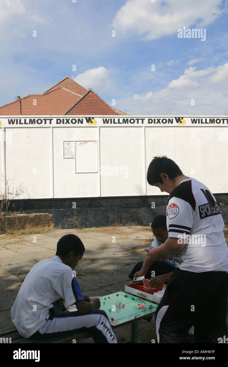 Jungs spielen das Brettspiel Monopoly auf einem alten Spielplatz auf einer Wohnsiedlung, regeneriert werden. Stockfoto