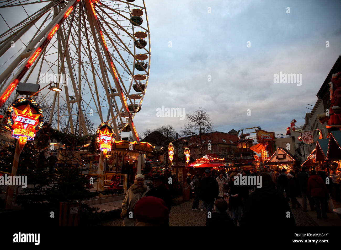 Touristen, die zu Fuß durch Spandau Weihnachten Markt in den späten Abend mit Riesenrad Berlin Deutschland Stockfoto