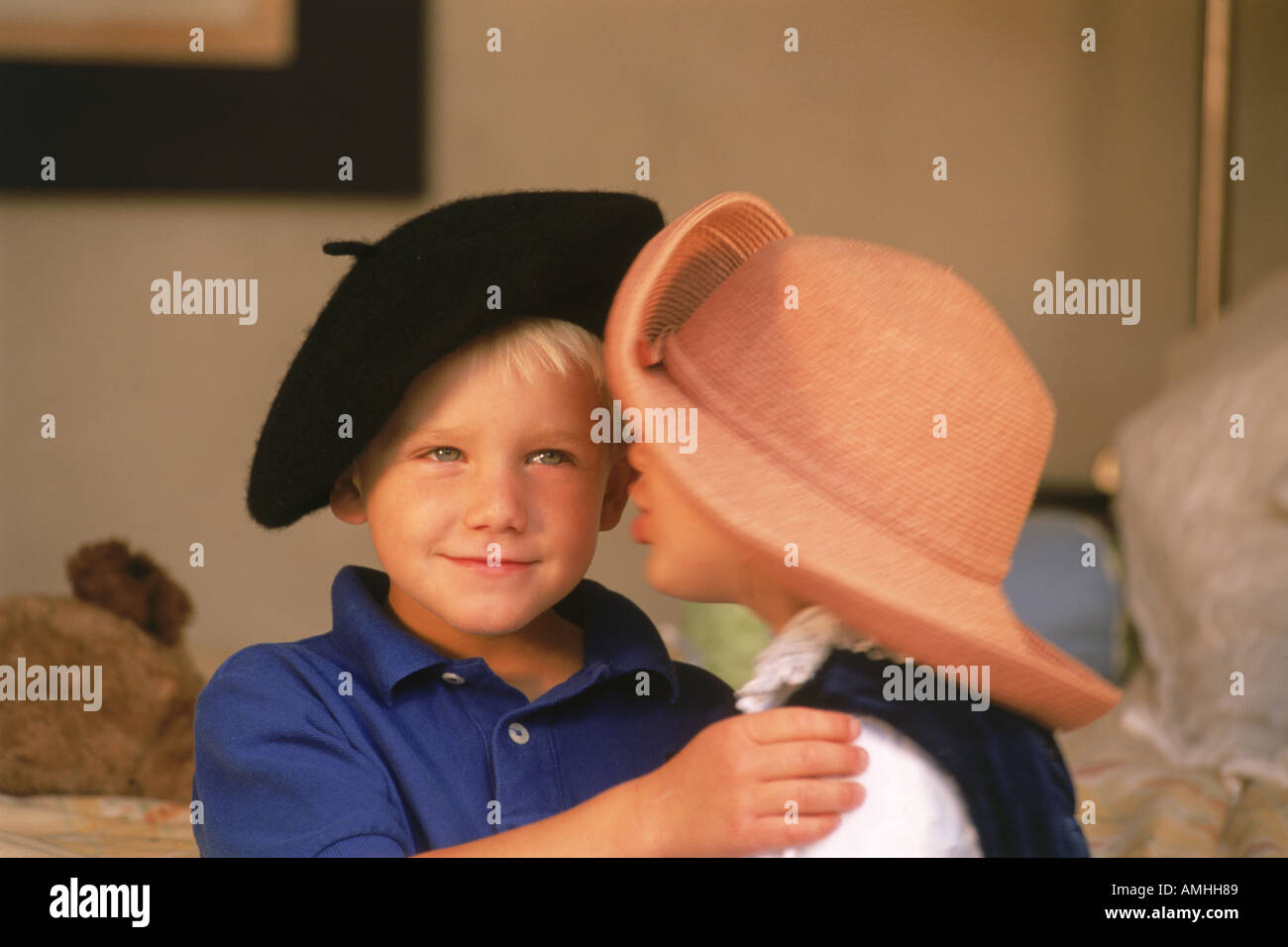 Jungen und Mädchen 3 bis 5 Jahre alt kuscheln mit Hüte auf zu Hause Stockfoto