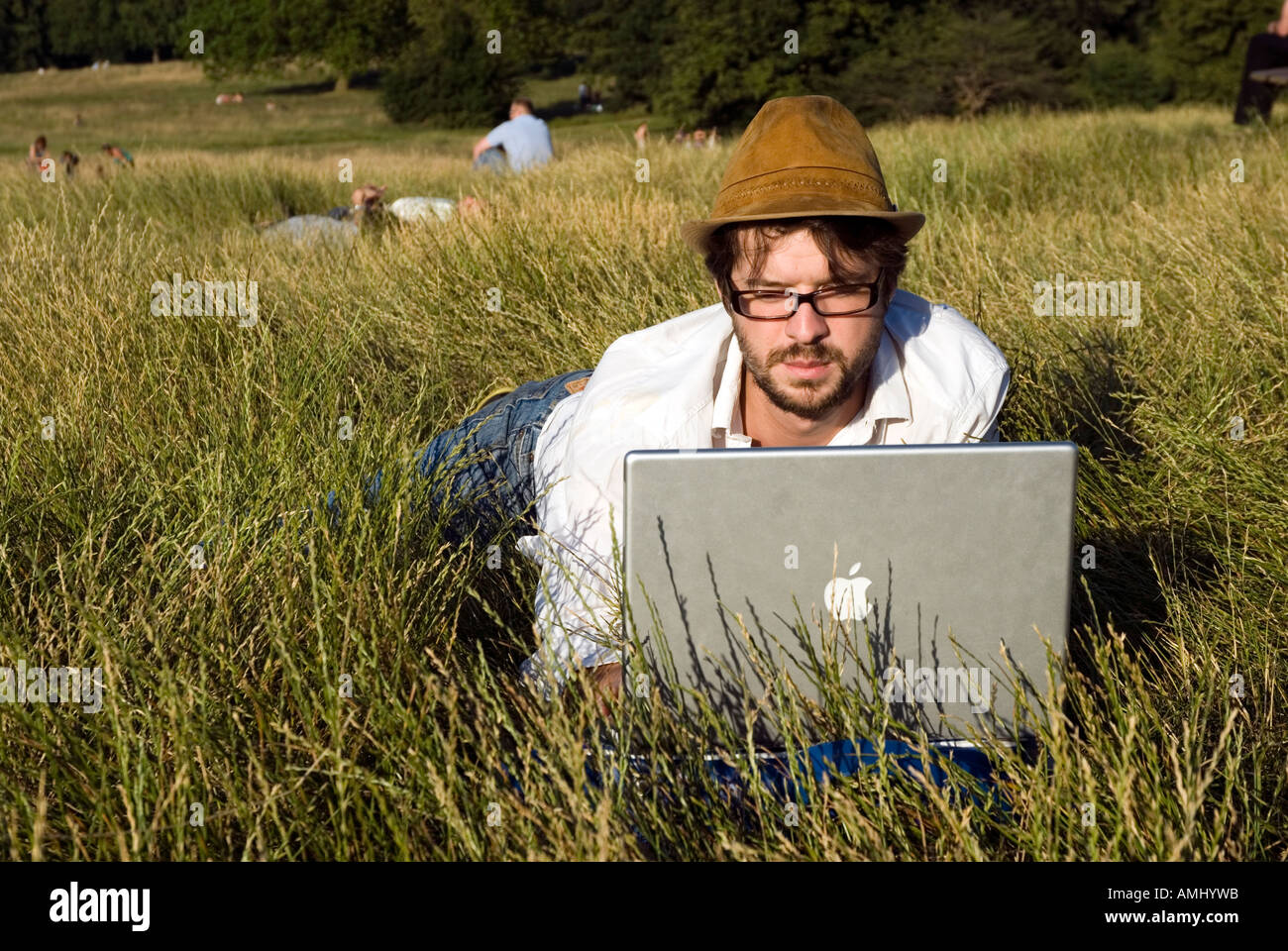 Mann mit einem Apple Laptop im Freien in Hampstead Heath, London, UK Stockfoto