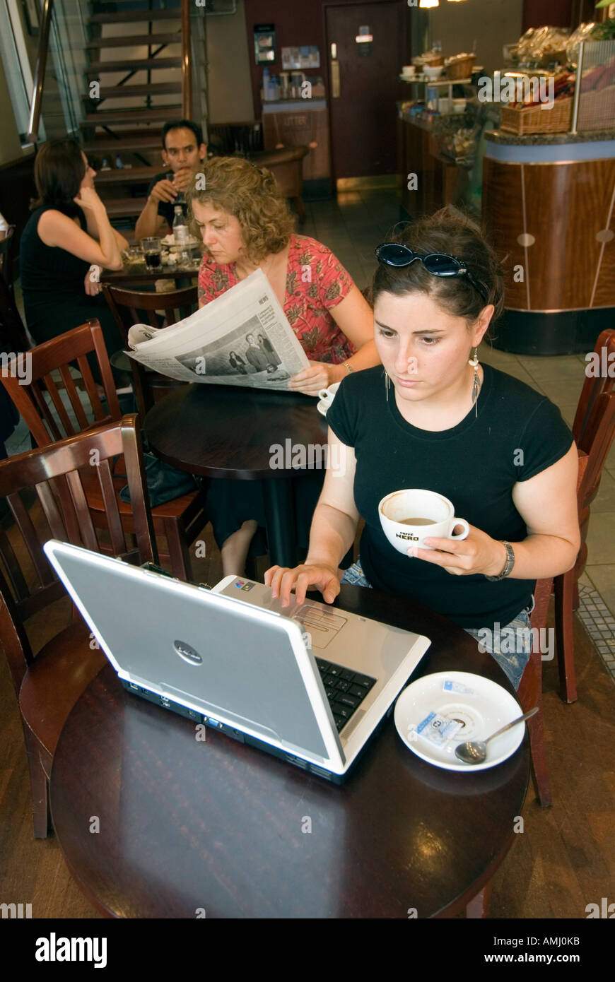 Junge Frau, die das Surfen im Internet auf einem Laptopcomputer in einem Caffe Nero, London, England, UK Stockfoto