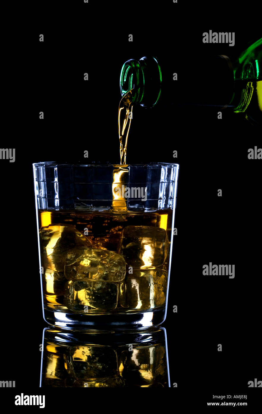 Whisky in einem Glas aus Eis vor schwarzem Hintergrund Stockfoto