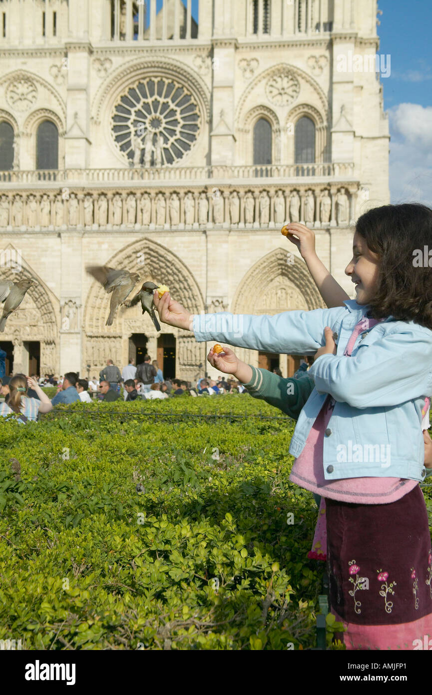 Mädchen spielen mit Vögel im Park neben der Notre Dame Kathedrale Paris Frankreich Stockfoto