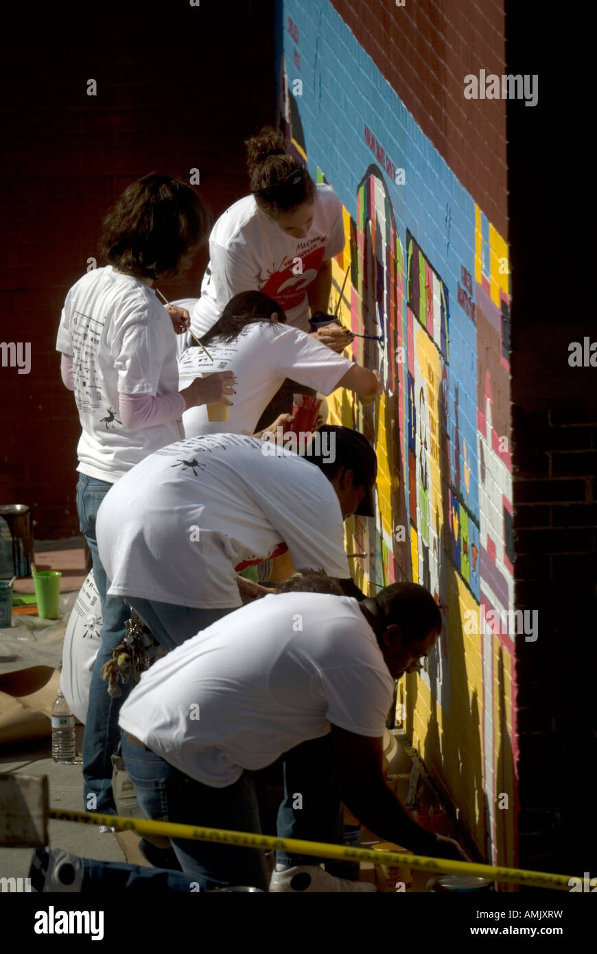 Freiwillige mit New York kümmert sich malen eine Wandbild auf der Seite der PS 33 Chelsea School in New York City Stockfoto